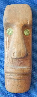 Carved wood face, green eyes pin